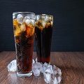 Cola in glass  and 
 ice cubes  on wooden background